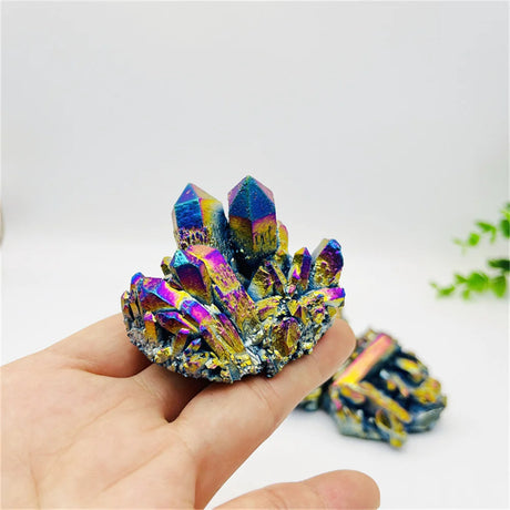 Multicolored crystal cluster held in a hand with a blurred background