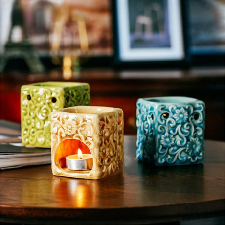 Three decorative candle holders on a wooden surface with a blurred background