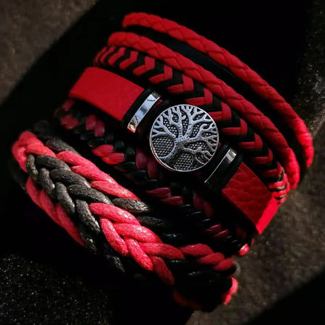 Red and black braided bracelet with a silver tree of life charm on a dark background