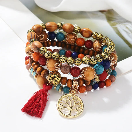 Colorful beaded bracelet with a gold tree of life charm on a white surface