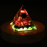 Triangular pyramid light with colorful LED lights on a dark background