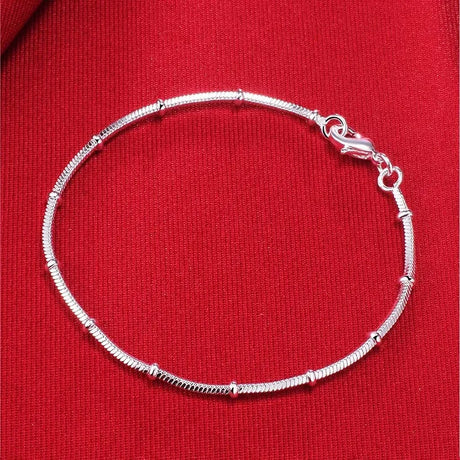 Silver bracelet on a red fabric background