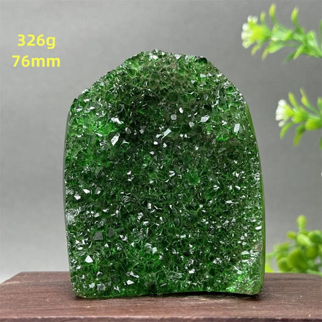 Green crystal rock on a wooden surface with a gray background