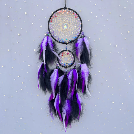 Dreamcatcher with purple and black feathers on a starry background