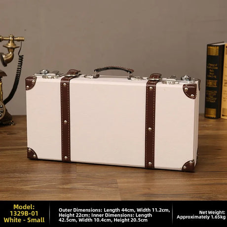 Vintage-style white suitcase with brown straps on a wooden surface, with dimensions and weight information displayed.