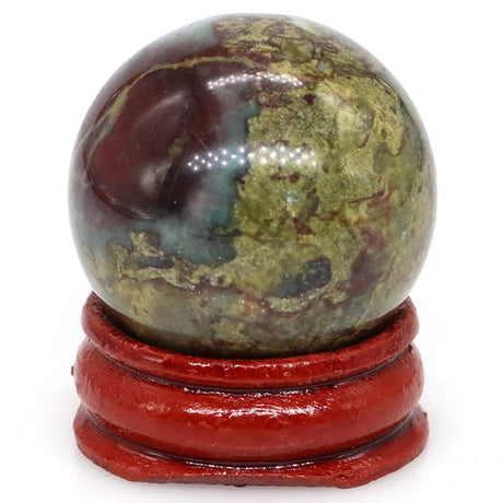 Multicolored spherical stone on a red stand against a white background