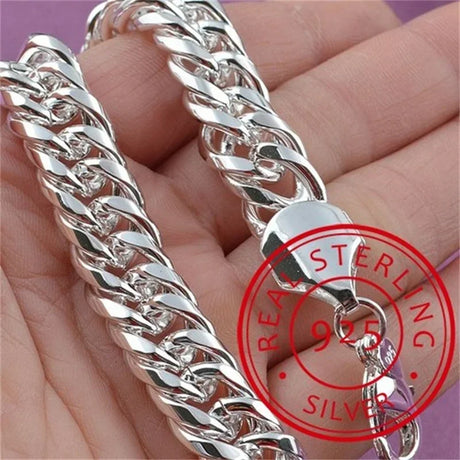 Silver chain bracelet held in hand with 'Real Sterling Silver 925' stamp.
