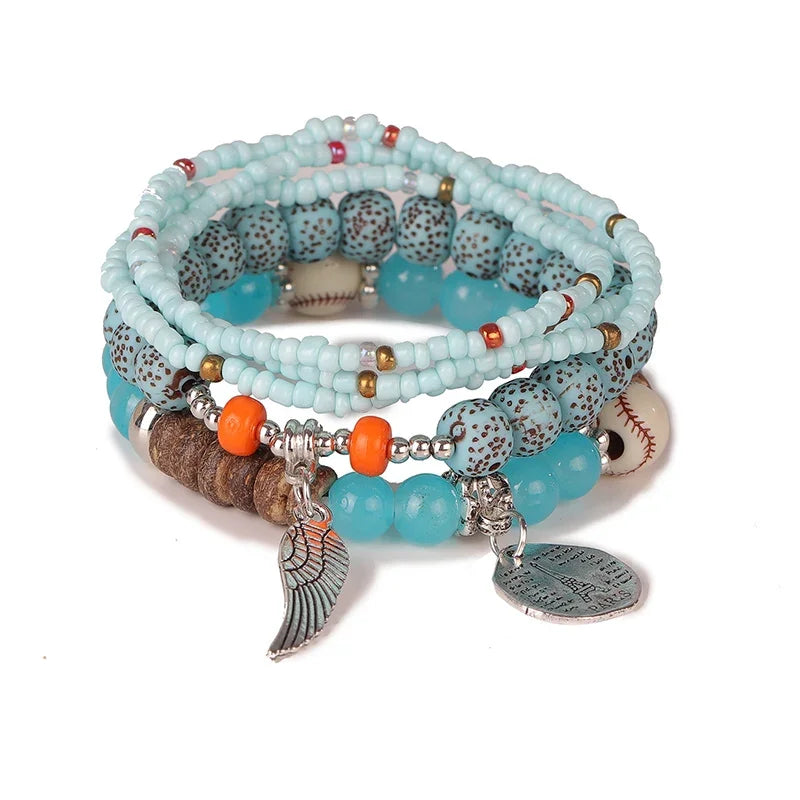 Stack of beaded bracelets with various charms on a white background