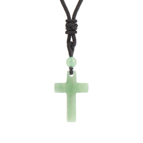 Green cross pendant on a black cord against a white background