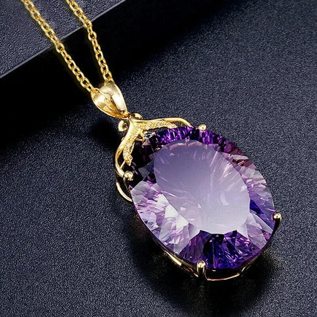 Purple amethyst pendant on a gold chain against a dark background