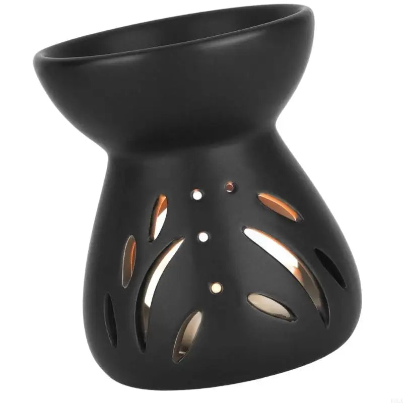 Black ceramic oil burner with cut-out designs on a white background