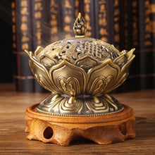 Decorative incense burner with intricate design on a wooden stand against a blurred background.