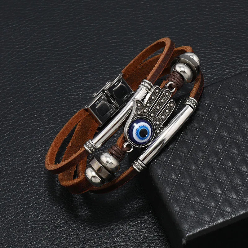 Multistrand leather bracelet with metal accents and an eye charm on a black textured surface