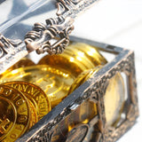 Decorative container with gold coins and intricate design on a white background