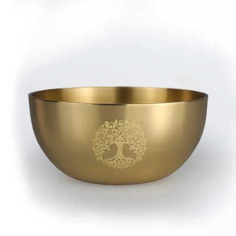 Gold bowl with a tree of life design on a white background