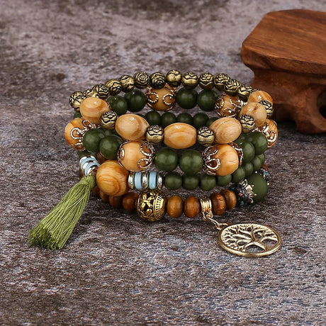 Multicolored beaded bracelet with a tree of life charm on a textured surface