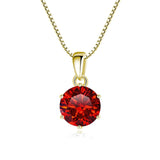 Gold necklace with a red gemstone pendant on a white background