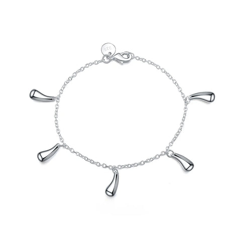 Silver bracelet with four dangling charms on a white background
