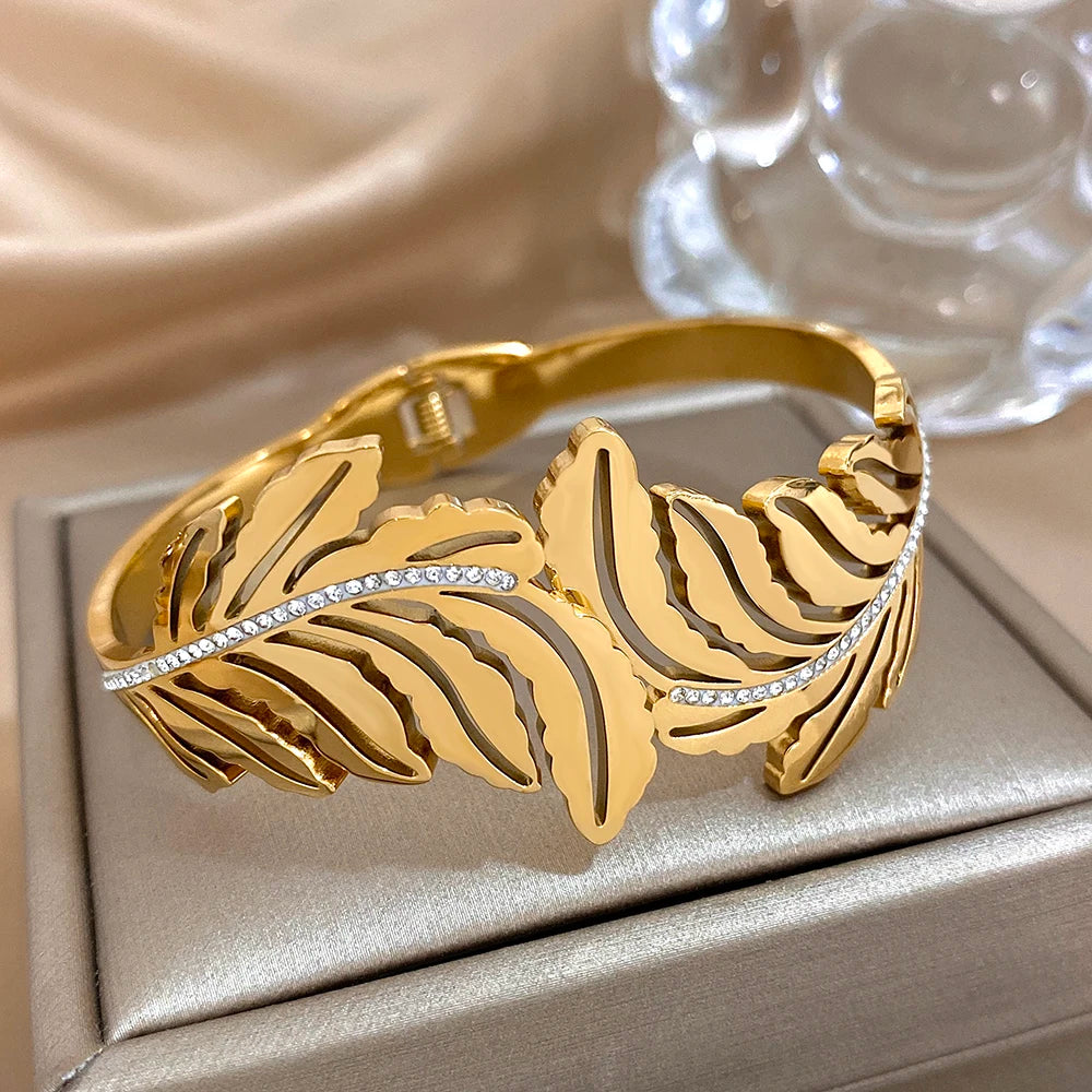 Gold bracelet with leaf design on a beige surface