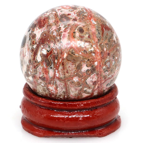 Marble-like sphere on a red stand against a white background