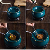 Teal ceramic bowl with gold rim on a wooden stand, being used to mix ingredients.