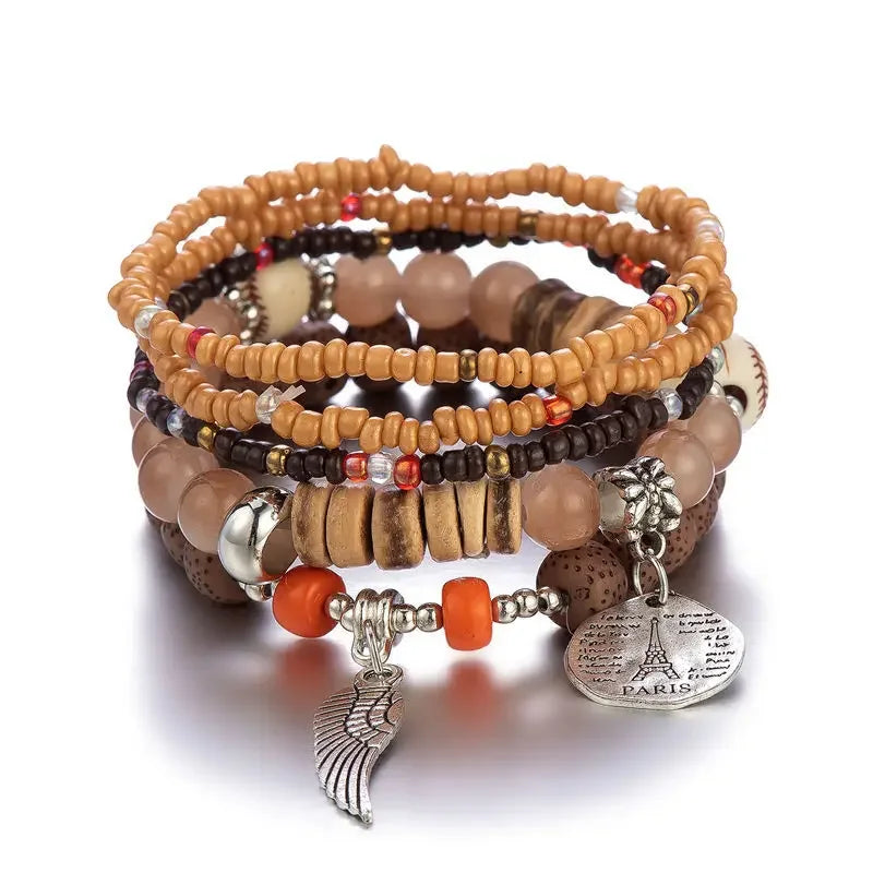 Stack of beaded bracelets with charms on a white background
