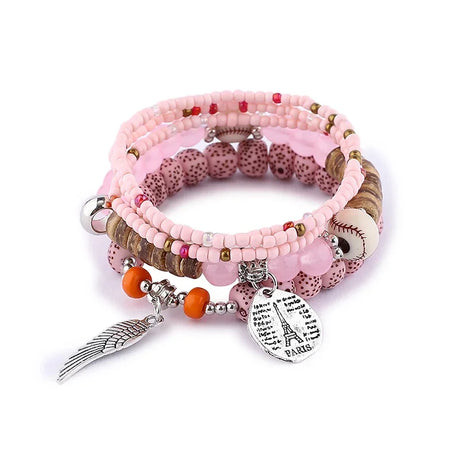 Stack of pink beaded bracelets with various charms on a white background
