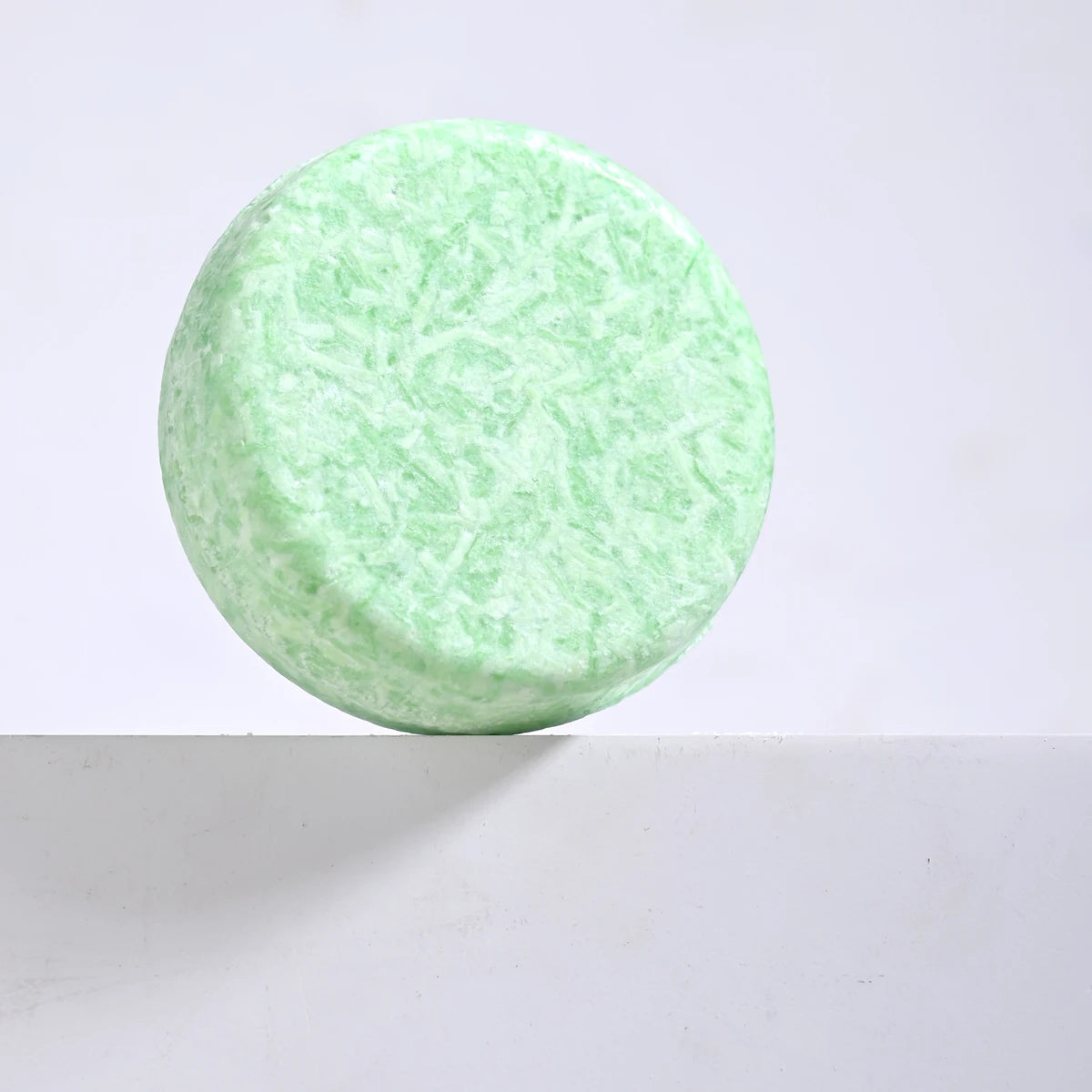 Green textured round object on a light gray background