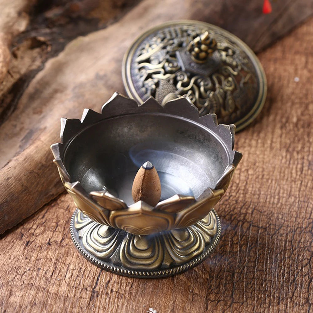 Decorative incense burner with a lit incense stick on a wooden surface