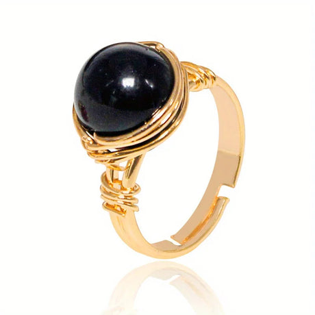 Gold ring with a black gemstone on a white background
