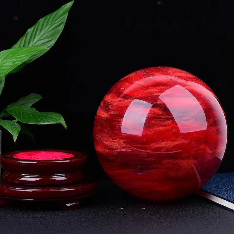 Red crystal ball with a dark background and plant