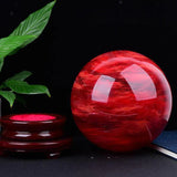 Red crystal ball with a dark background and plant