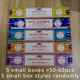 Collection of Nag Champa incense boxes on a wooden surface with text indicating quantity and box styles.