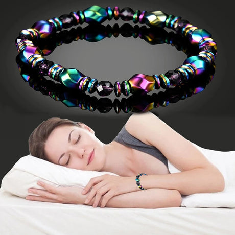 Woman sleeping with a colorful beaded bracelet on her wrist against a dark background