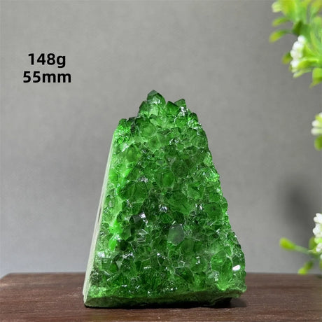Green crystal on a wooden surface with a gray background