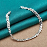 Silver bracelet on a turquoise fabric background