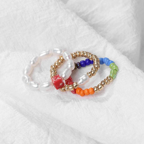Set of colorful beaded bracelets on a white fabric background