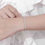 Silver bracelet on a wrist with a soft white background