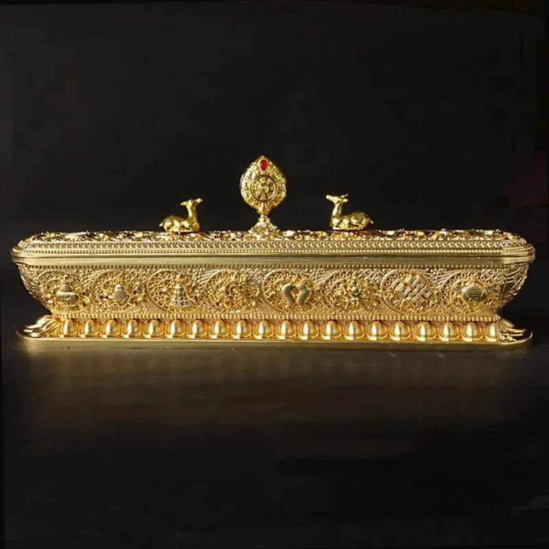 Decorative gold box with intricate designs on a black background