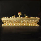 Decorative gold box with intricate designs on a black background