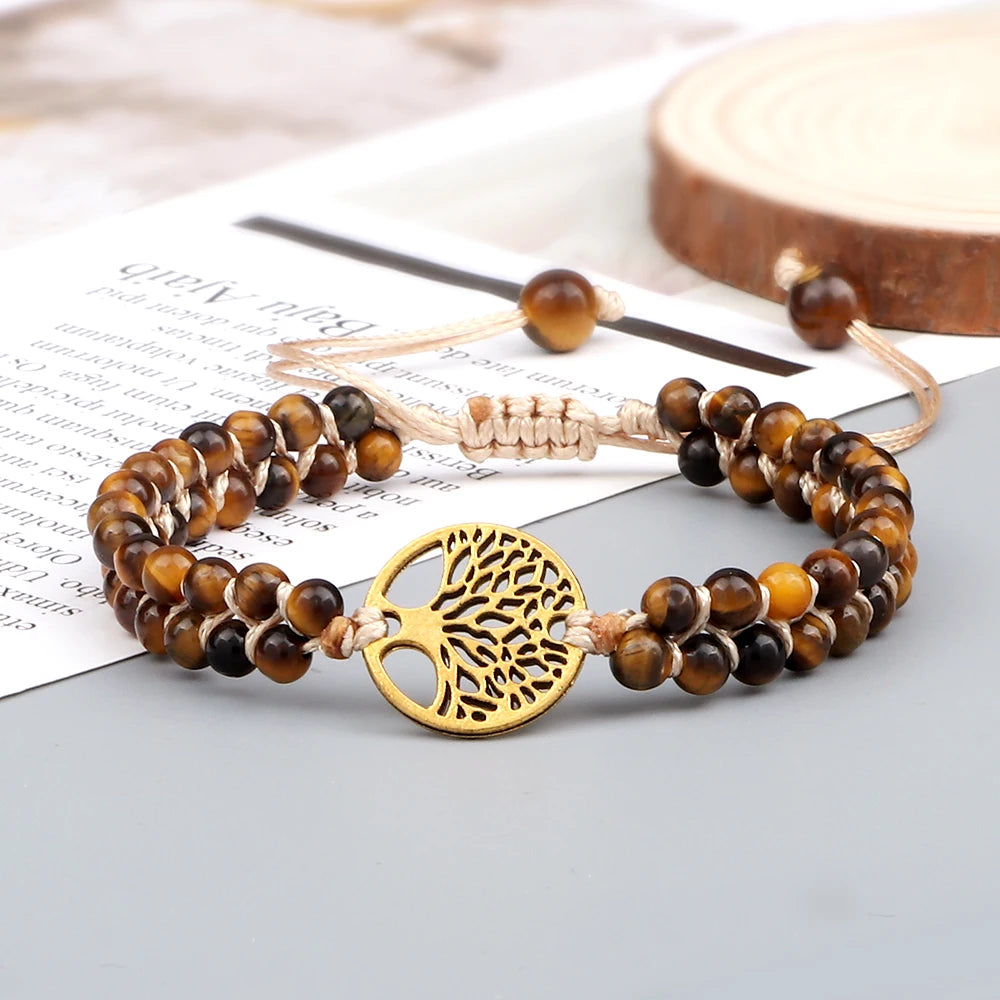 Bracelet with tiger eye beads and gold tree of life charm on a newspaper background