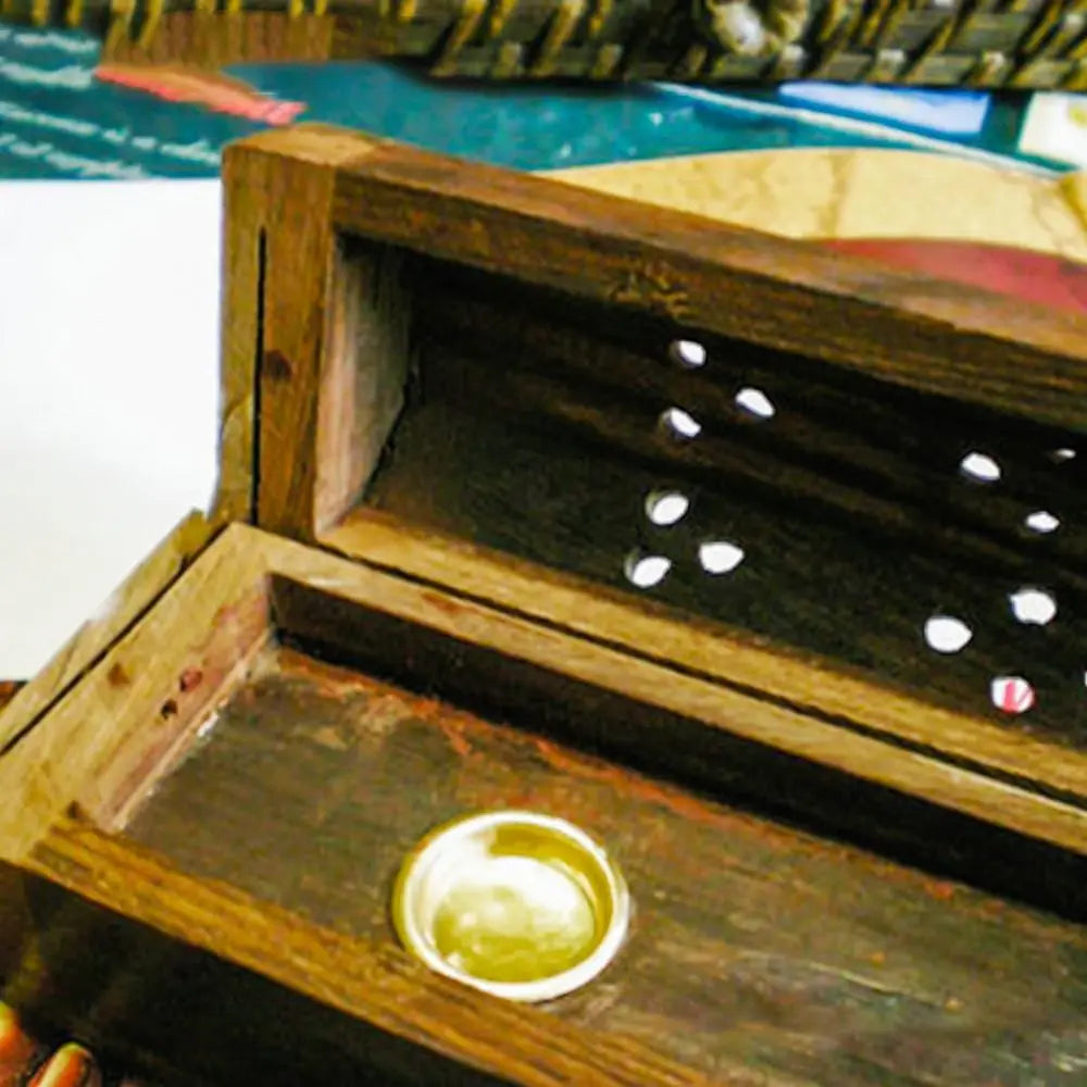Wooden box with a circular object inside, possibly a coin, on a blurred background.