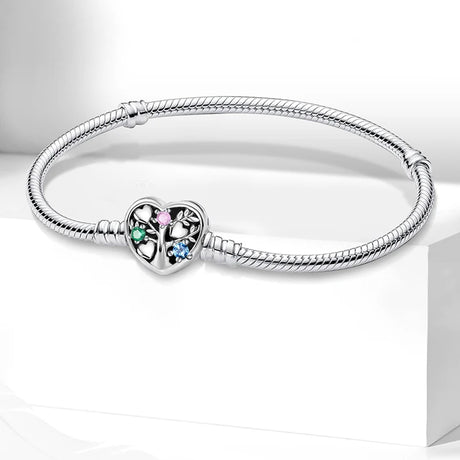 Silver bracelet with a heart-shaped clasp featuring colorful stones on a white background