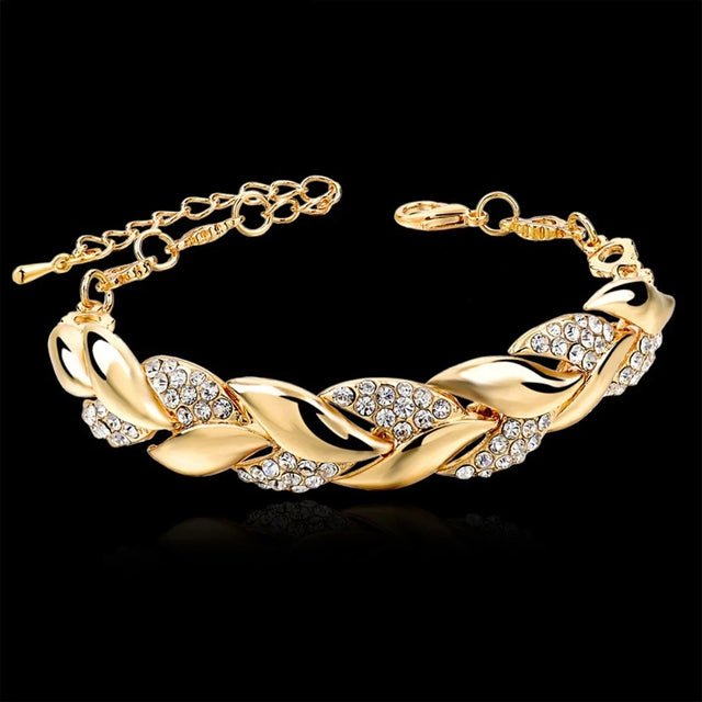 Gold bracelet with crystal accents on a black background