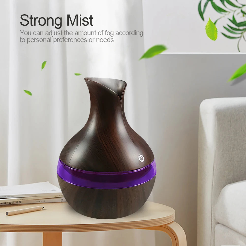 Wooden diffuser with purple base on a table in a room setting