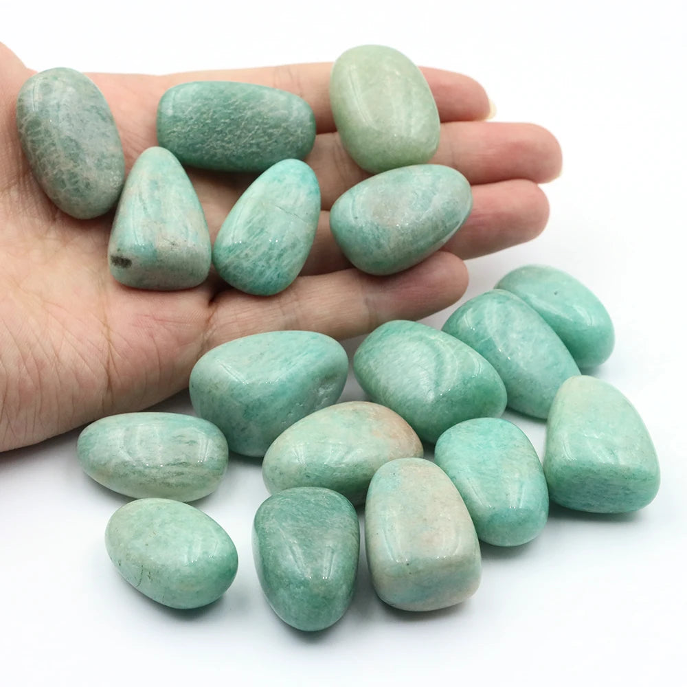 Turquoise stones held in a hand with more stones on a white background