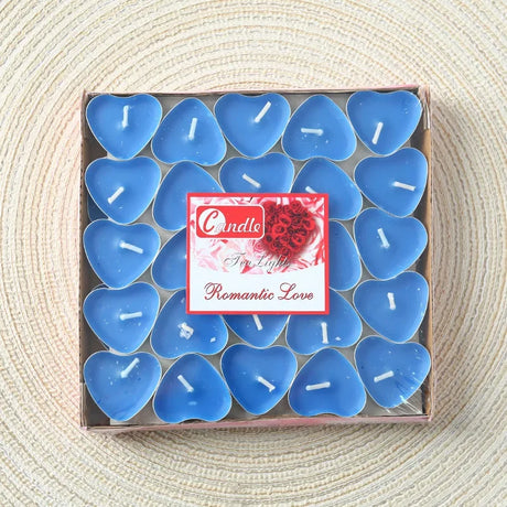 Box of blue heart-shaped candles with a decorative label on a textured surface