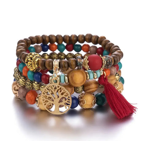 Stack of colorful beaded bracelets with a gold tree of life charm on a white background