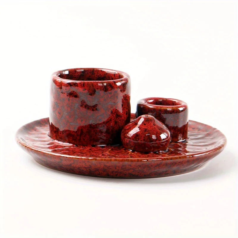 Red ceramic set with a bowl, cup, and small dish on a white background
