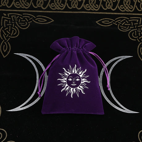 Purple drawstring bag with sun and moon design on a black background with Celtic patterns